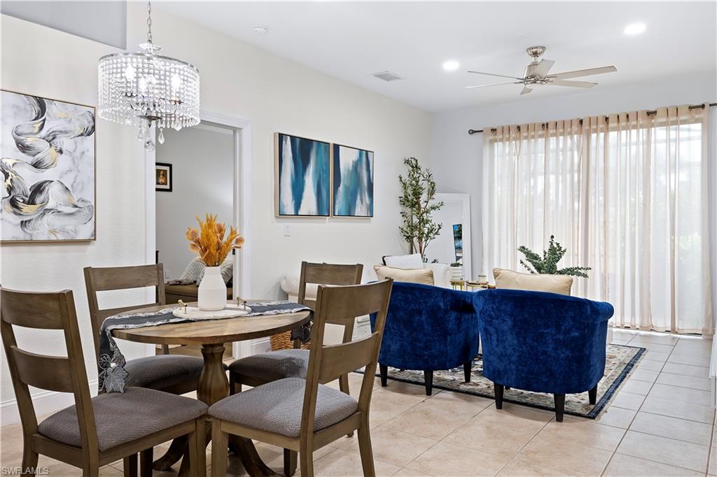 7542 Bristol Circle Naples, FL 34120 - Photo 7 of 26 Dining area featuring light tile patterned flooring and ceiling fan with notable chandelier