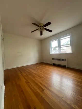 an empty room with windows and ceiling fan