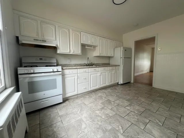 a kitchen with white cabinets and white appliances