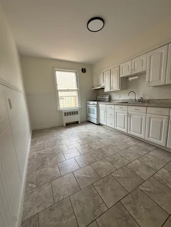 a kitchen with stainless steel appliances a sink a stove a refrigerator and cabinets