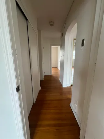a view of a hallway with wooden floor and staircase