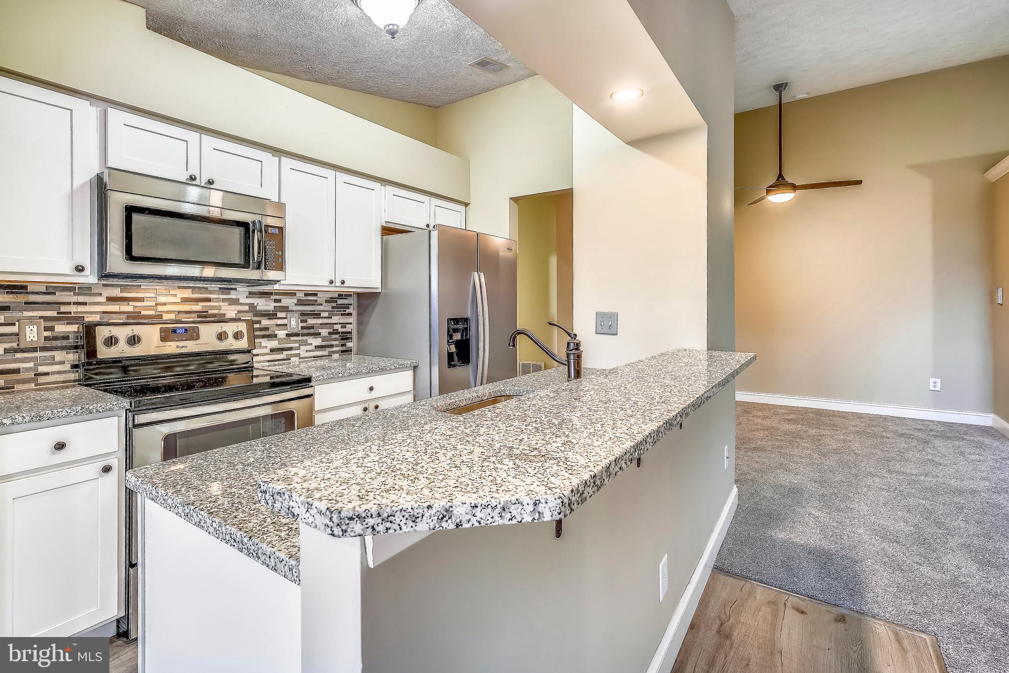 2408 Forest Edge Court, Unit 303 Odenton, MD 21113 - Photo 12 of 46 a kitchen with stainless steel appliances granite countertop a sink stove and refrigerator