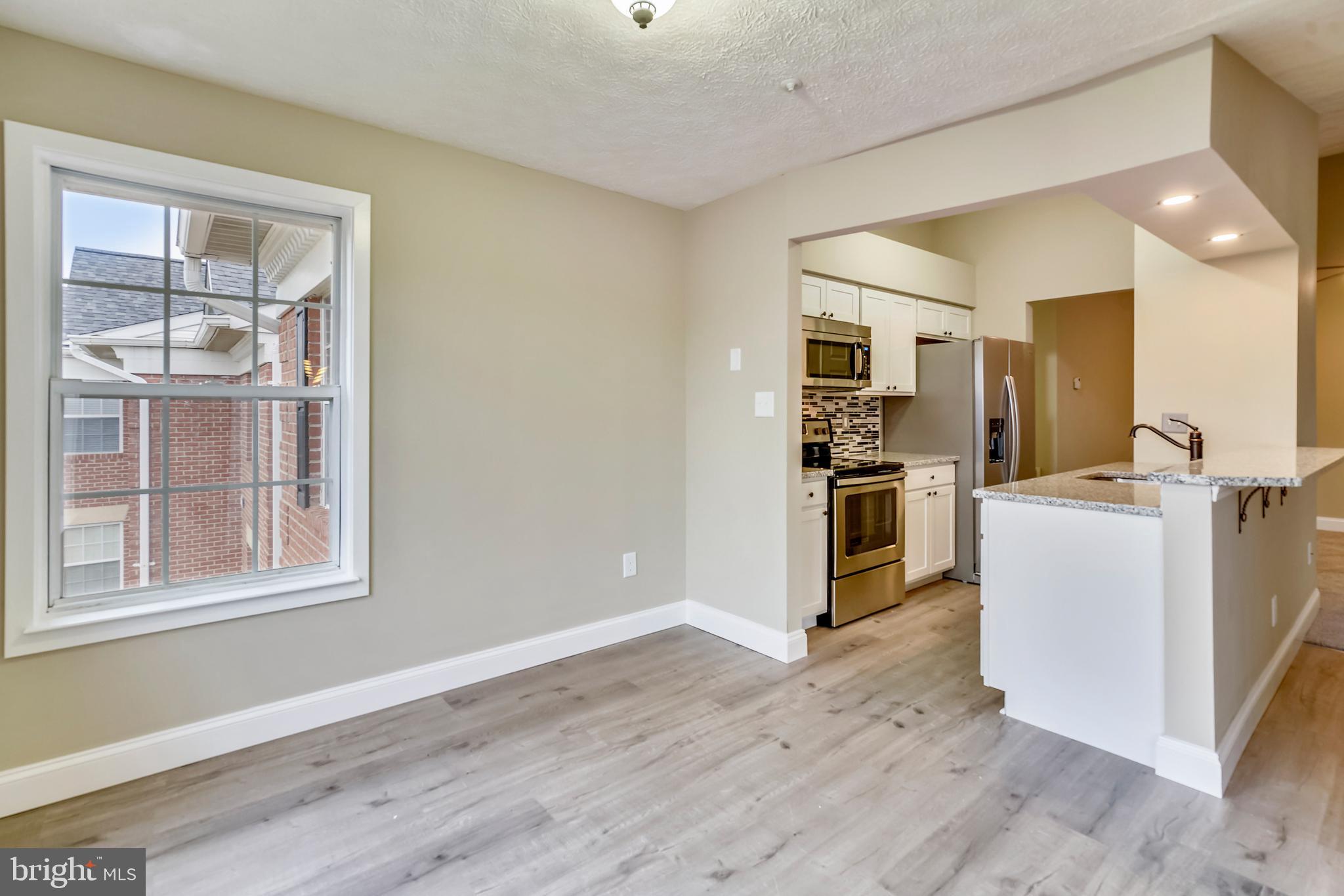 2408 Forest Edge Court, Unit 303 Odenton, MD 21113 - Photo 6 of 46 a view of kitchen with furniture and wooden floor