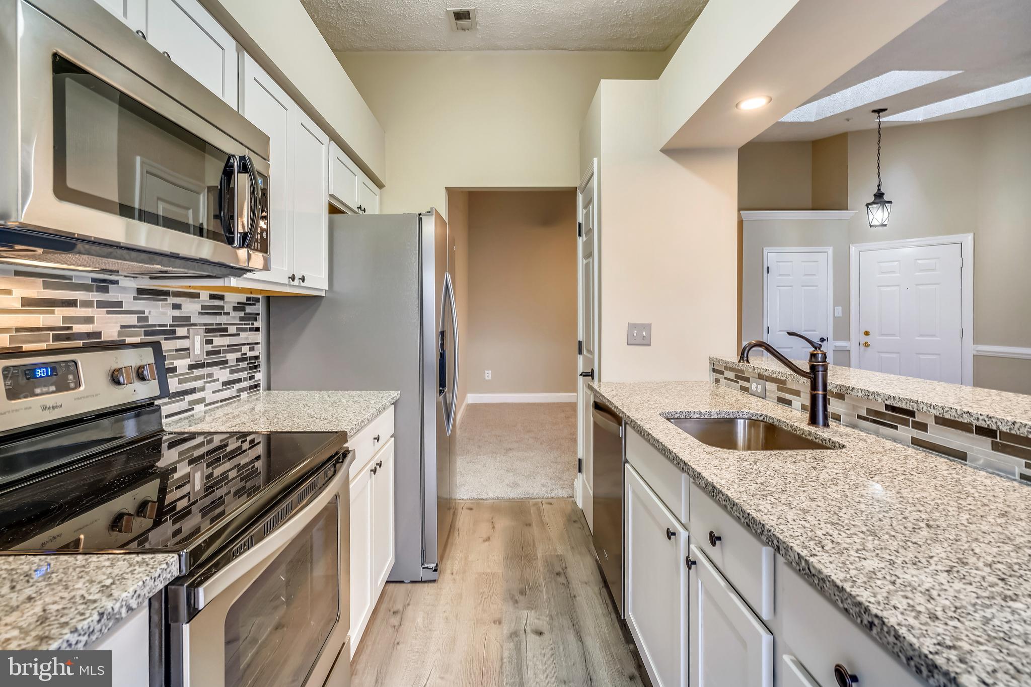 2408 Forest Edge Court, Unit 303 Odenton, MD 21113 - Photo 9 of 46 a kitchen with stainless steel appliances granite countertop a sink stove and refrigerator