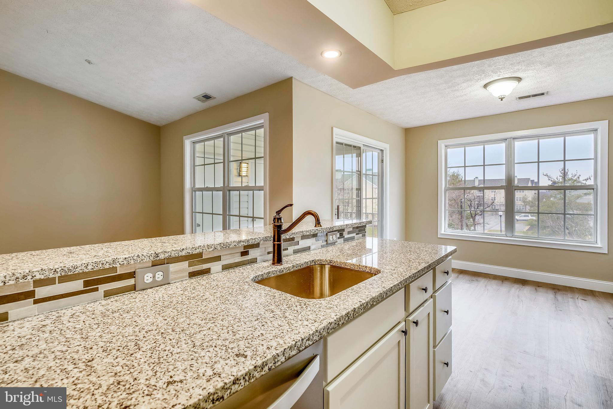 2408 Forest Edge Court, Unit 303 Odenton, MD 21113 - Photo 10 of 46 a kitchen with a sink and a wooden floor