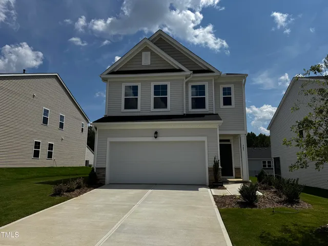 a front view of a house with a yard and a garage