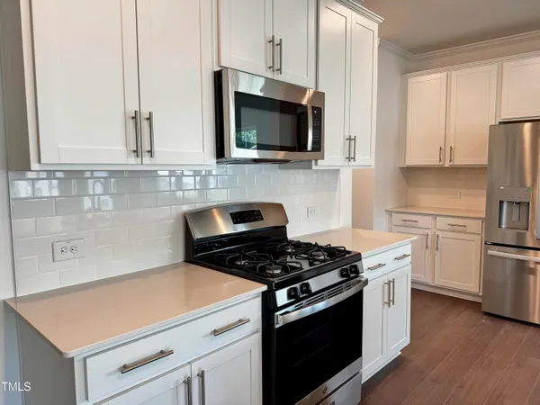a kitchen with appliances a sink and cabinets
