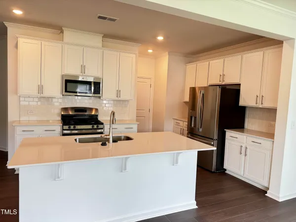 a kitchen with stainless steel appliances a stove refrigerator sink and microwave