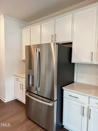 a metallic refrigerator freezer sitting in a kitchen