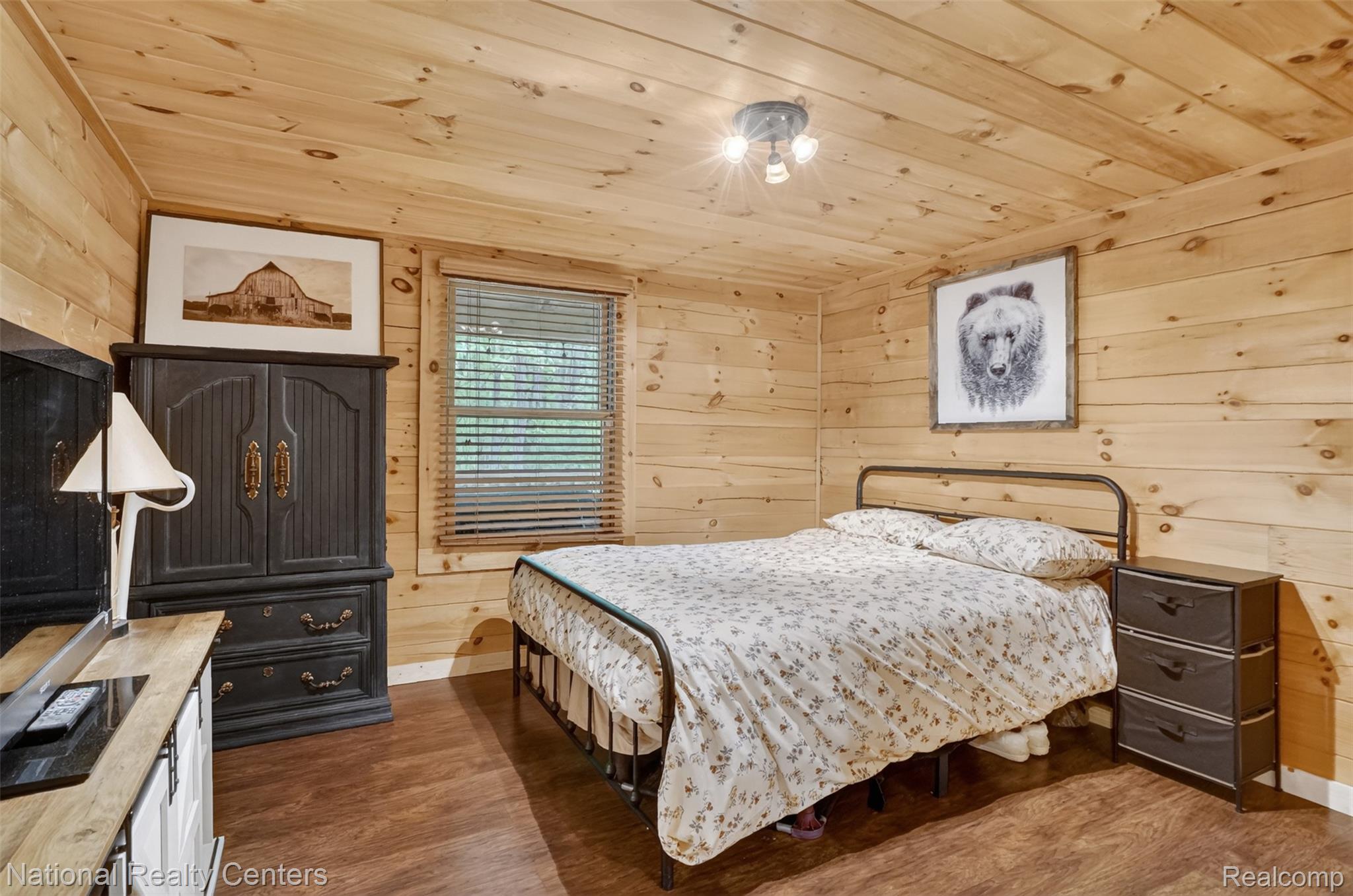 7782 Golf Club Road Howell, MI 48843 - Photo 12 of 27 Interior room featuring wood-finish wall and ceiling paneling, wood-finish flooring, a window with wood blinds, and a three-bulb ceiling light fixture