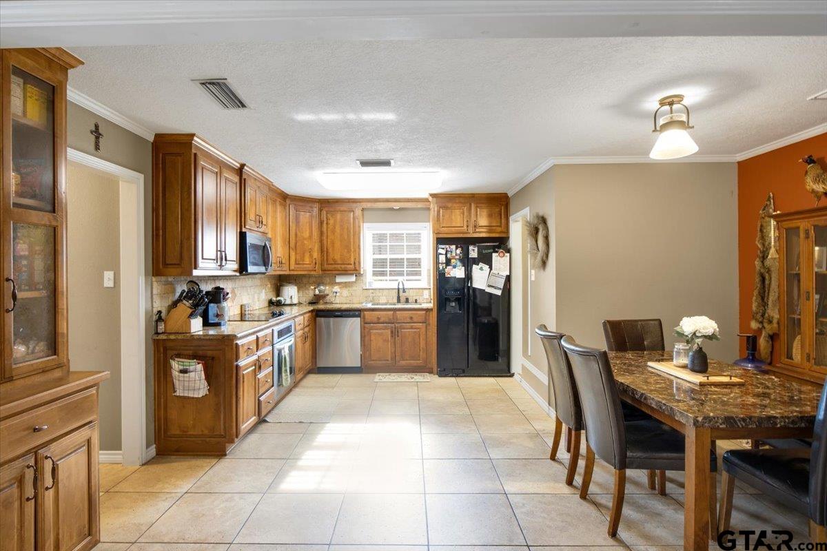 906 Zola Street Quitman, TX 75783 - Photo 19 of 41 a kitchen with stainless steel appliances granite countertop a stove top oven a sink dishwasher and a refrigerator
