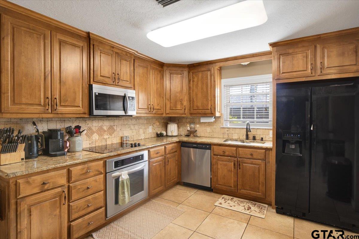 906 Zola Street Quitman, TX 75783 - Photo 20 of 41 a kitchen with stainless steel appliances granite countertop a sink stove and microwave