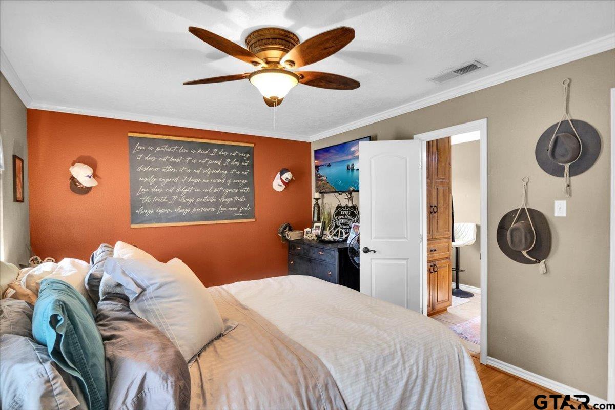 906 Zola Street Quitman, TX 75783 - Photo 24 of 41 a bedroom with a bed and a large mirror with a chandelier