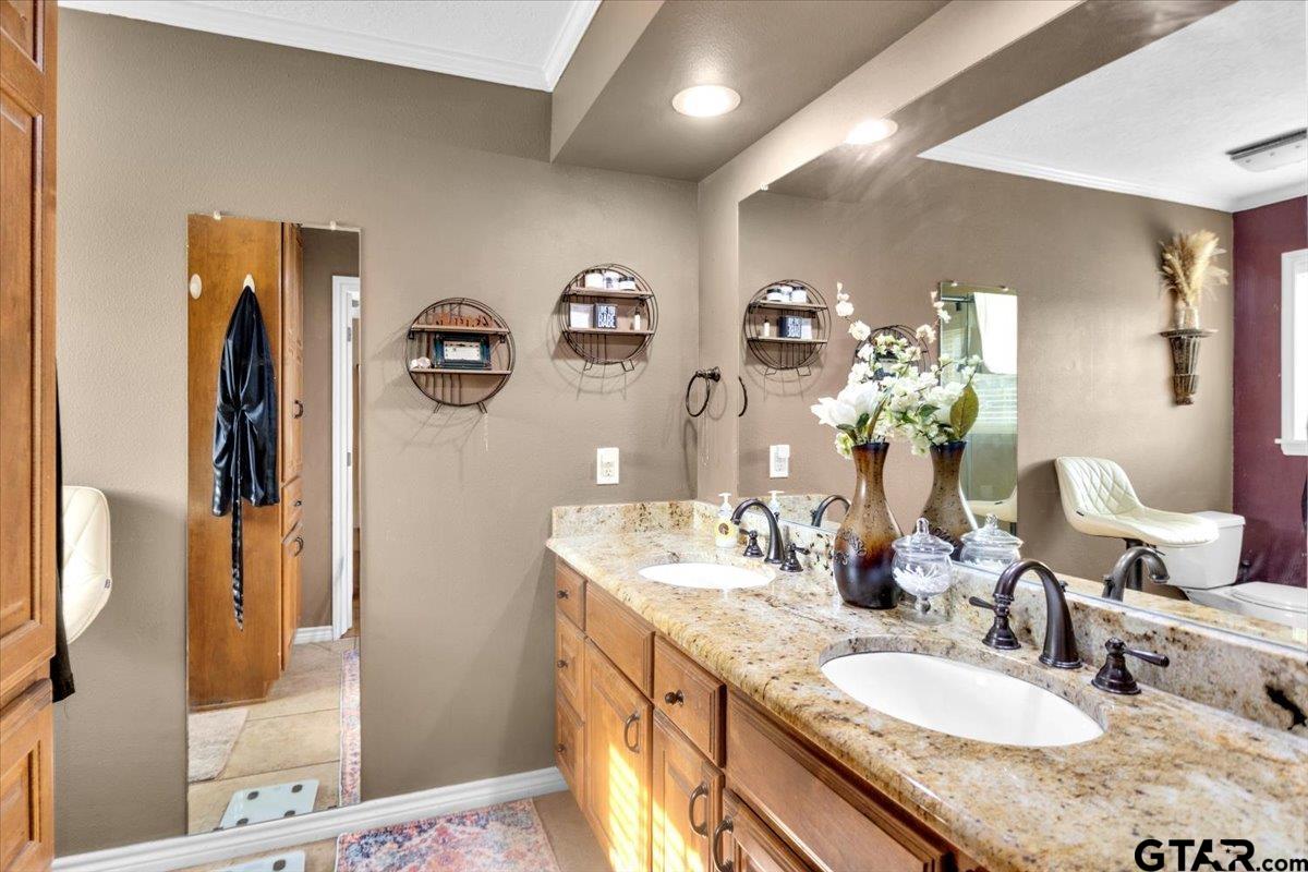 906 Zola Street Quitman, TX 75783 - Photo 27 of 41 a bathroom with a granite countertop sink and a mirror