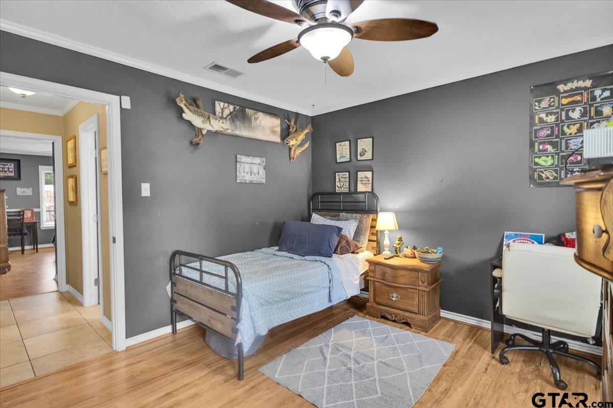 906 Zola Street Quitman, TX 75783 - Photo 37 of 41 a bedroom with a bed and a chandelier