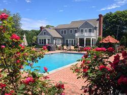 a front view of a house with a big yard and potted plants