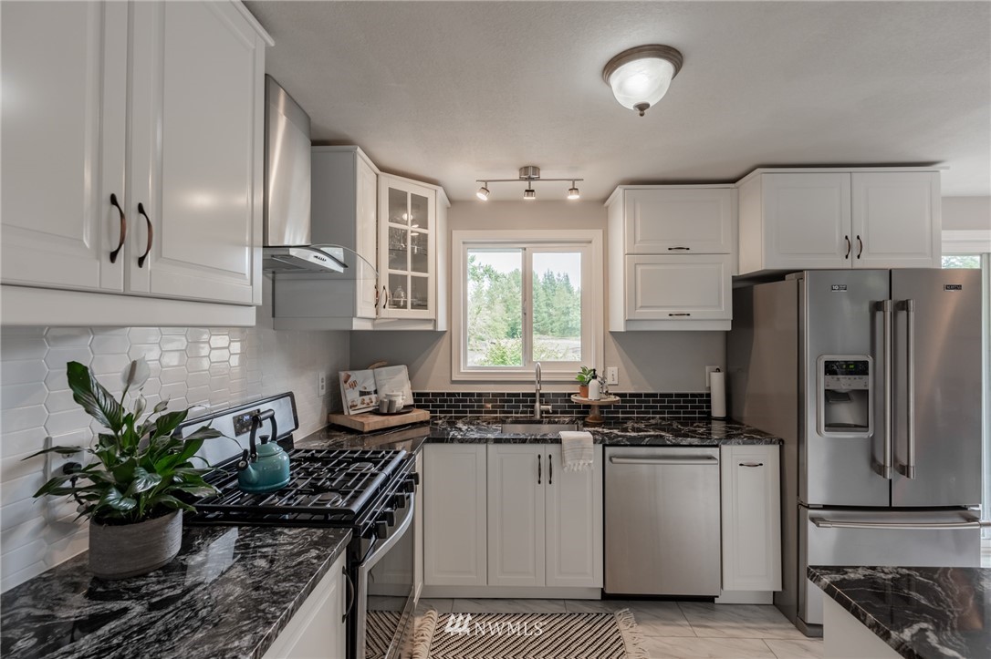 5946 Longdin Road Ferndale, WA 98248 - Photo 3 of 40 a kitchen with a refrigerator and a white cabinets