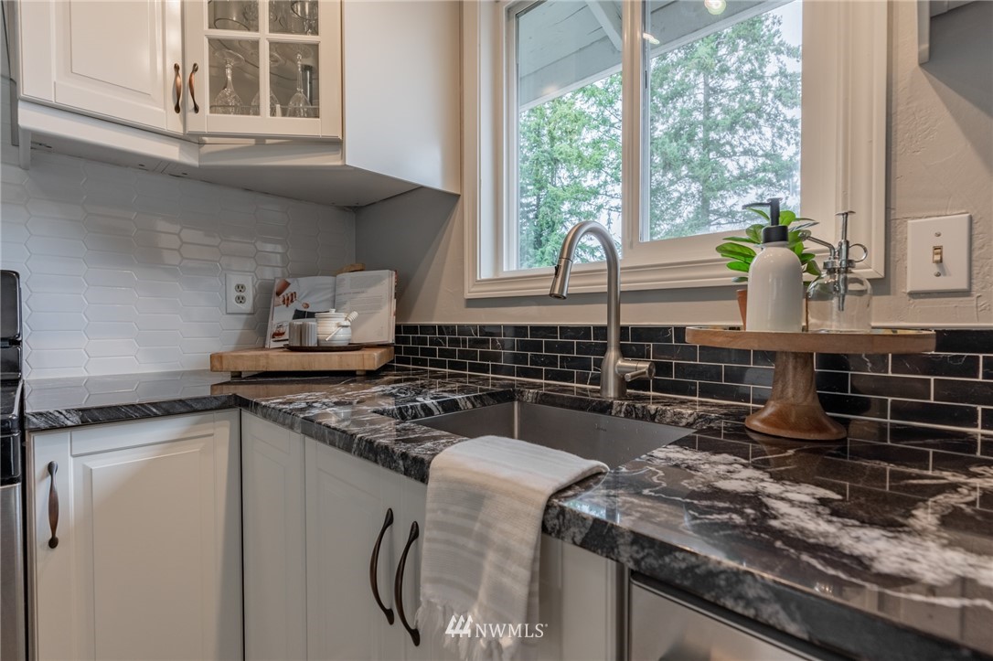5946 Longdin Road Ferndale, WA 98248 - Photo 5 of 40 a kitchen with a stove a sink and a wooden cabinets