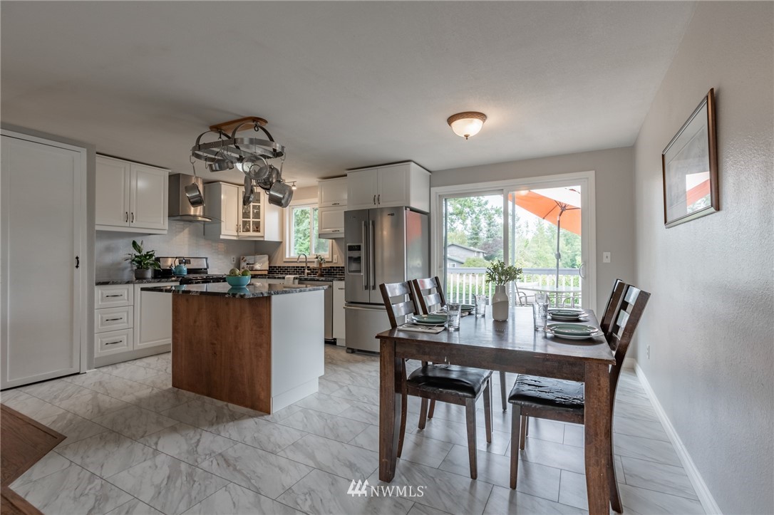 5946 Longdin Road Ferndale, WA 98248 - Photo 8 of 40 a kitchen with a dining table chairs and refrigerator