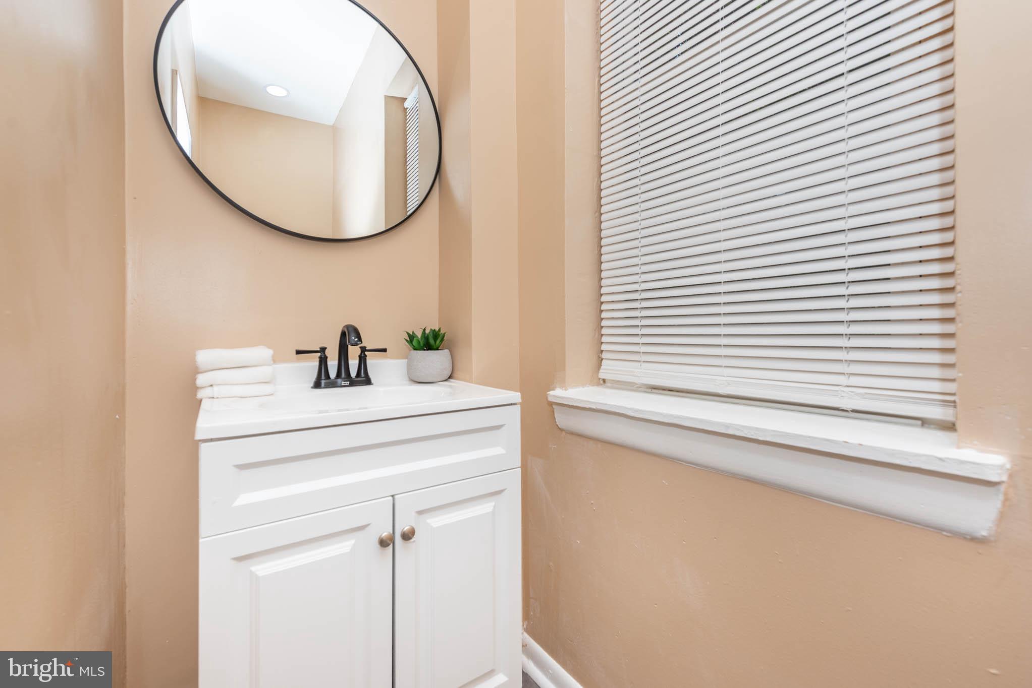 1705 East 25th Street Baltimore, MD 21213 - Photo 14 of 21 a bathroom with a sink and a mirror