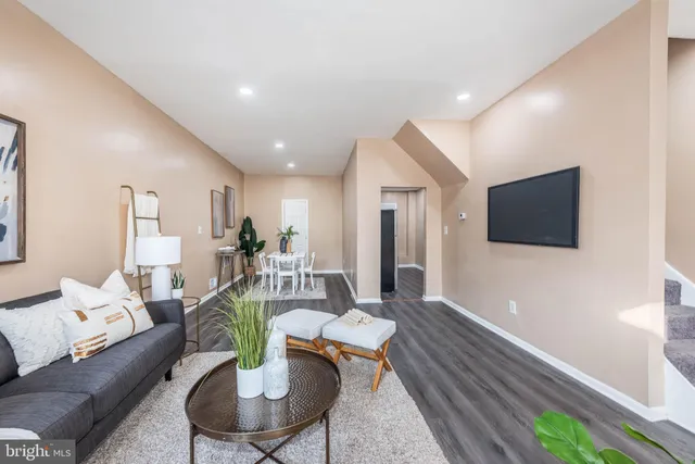 a living room with furniture a flat screen tv and a large window