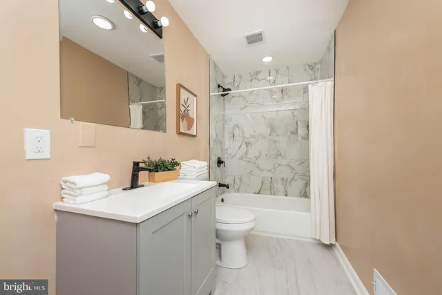 a bathroom with a sink toilet vanity and shower