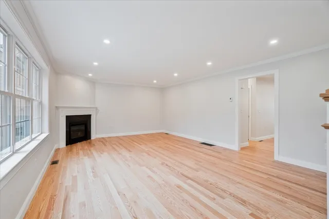 a view of empty room with wooden floor and fireplace