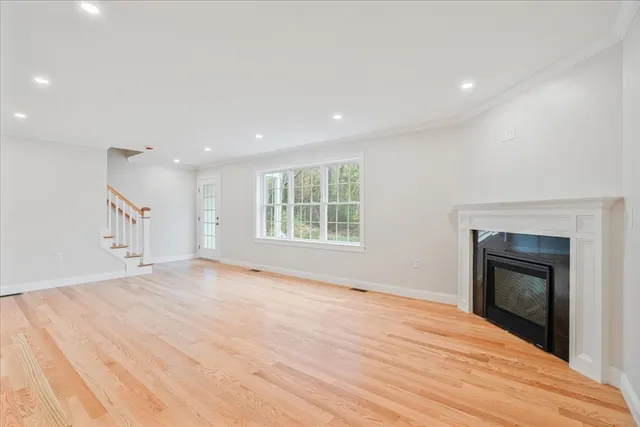 a view of empty room with wooden floor and fireplace