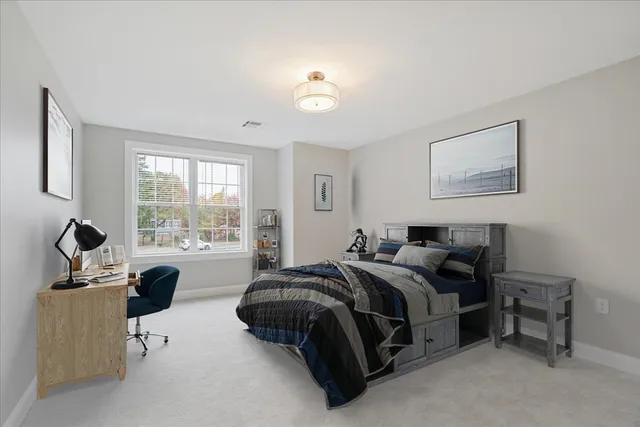 a bedroom with a bed and a couch next to a window