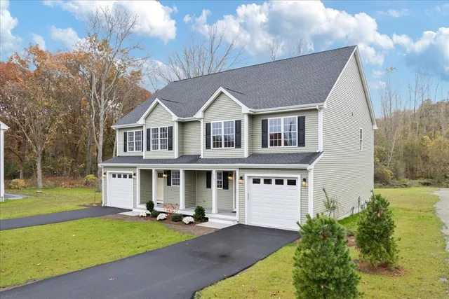 a view of a white house with a big yard and potted plants