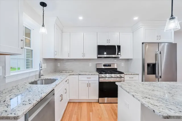 a kitchen with a sink stove top oven and refrigerator