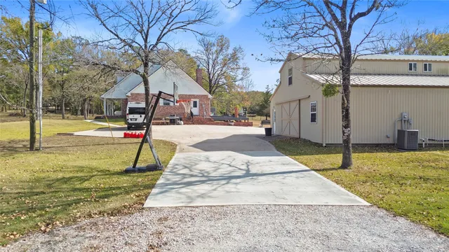 a view of a house with backyard and trees