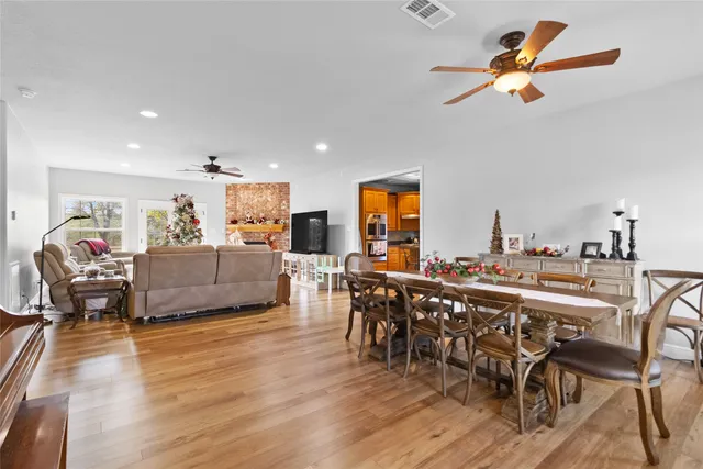 a living room with furniture a ceiling fan and a wooden floor