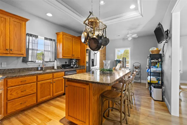 a kitchen with stainless steel appliances kitchen island granite countertop a stove a sink and a refrigerator
