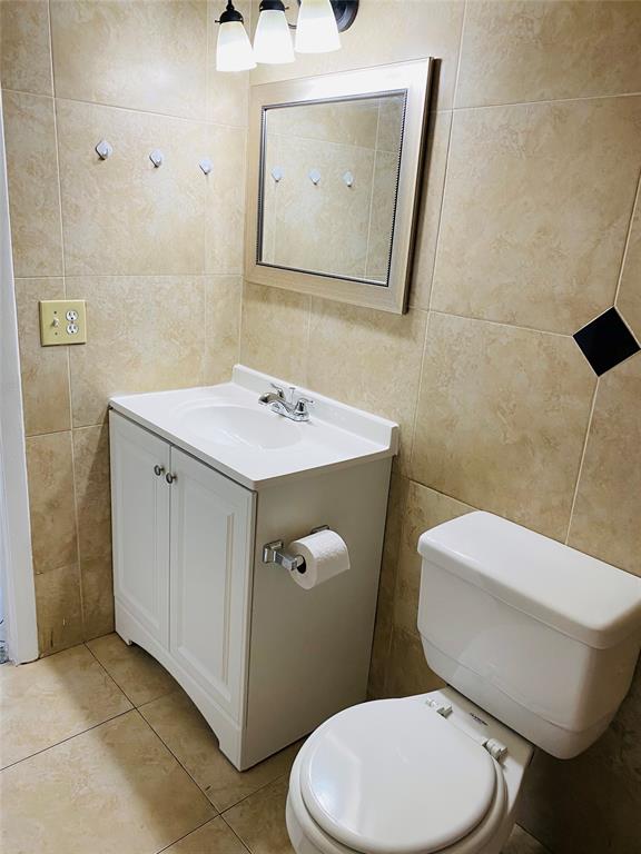 10046 Winding Lake Road, Unit 203 Sunrise, FL 33351 - Photo 8 of 31 a bathroom with a toilet a sink and mirror