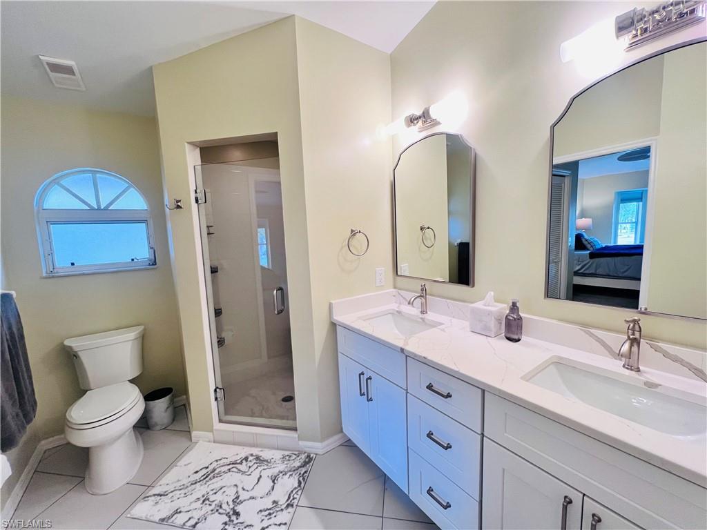 8073 Panther Trail, Unit 1404 Naples, FL 34113 - Photo 17 of 29 a bathroom with a double vanity sink and a mirror