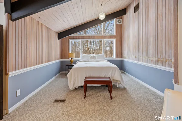 a bedroom with a bed and a large window