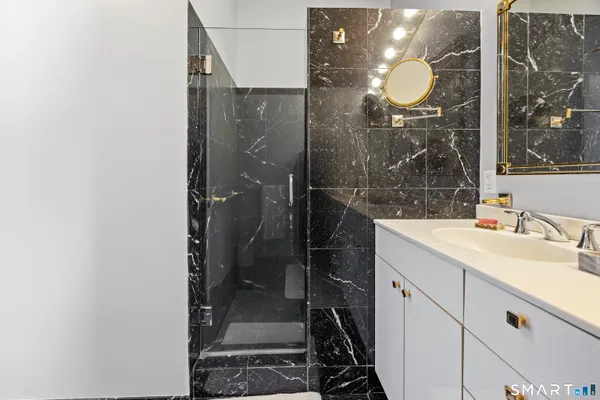 a bathroom with a mirror sink and glass door shower