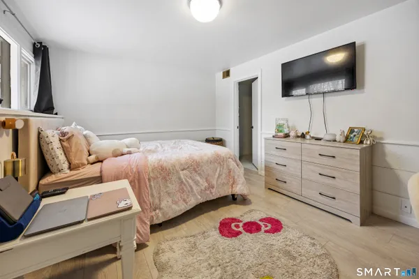a bedroom with a bed and a flat screen tv