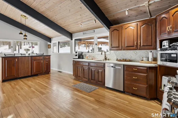 a kitchen with stainless steel appliances granite countertop a sink cabinets and wooden floors