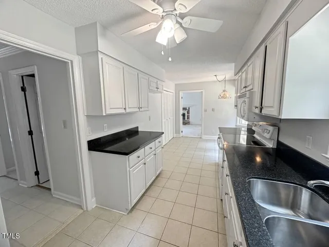 a sink with white cabinets and a granite counter top