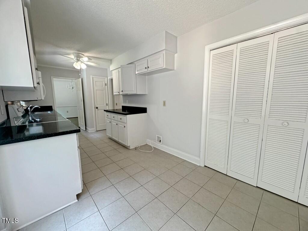8909 Creekstone Court, Unit 11 Raleigh, NC 27615 - Photo 12 of 39 a kitchen with white cabinets and white appliances