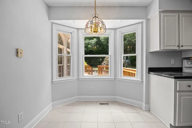 an empty room with windows and chandelier