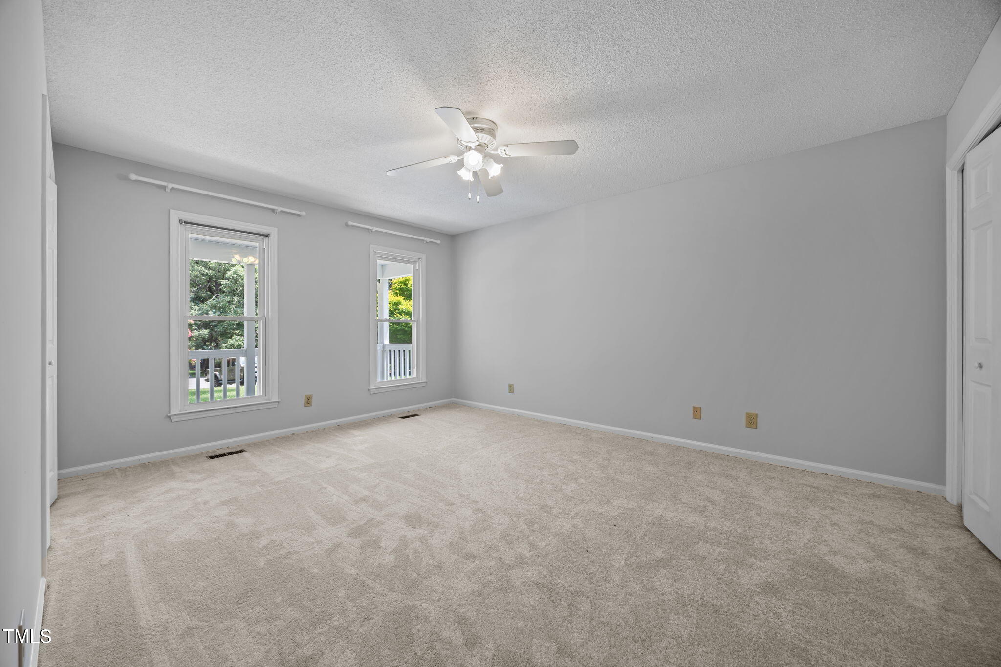 8909 Creekstone Court, Unit 11 Raleigh, NC 27615 - Photo 20 of 39 an empty room with windows and ceiling fan