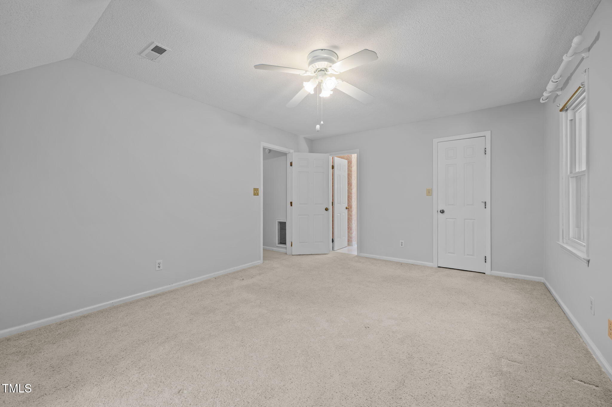 8909 Creekstone Court, Unit 11 Raleigh, NC 27615 - Photo 23 of 39 an empty room with chandelier fan and windows