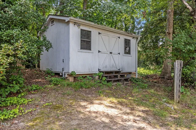 a view of a house with a small yard and wooden fence