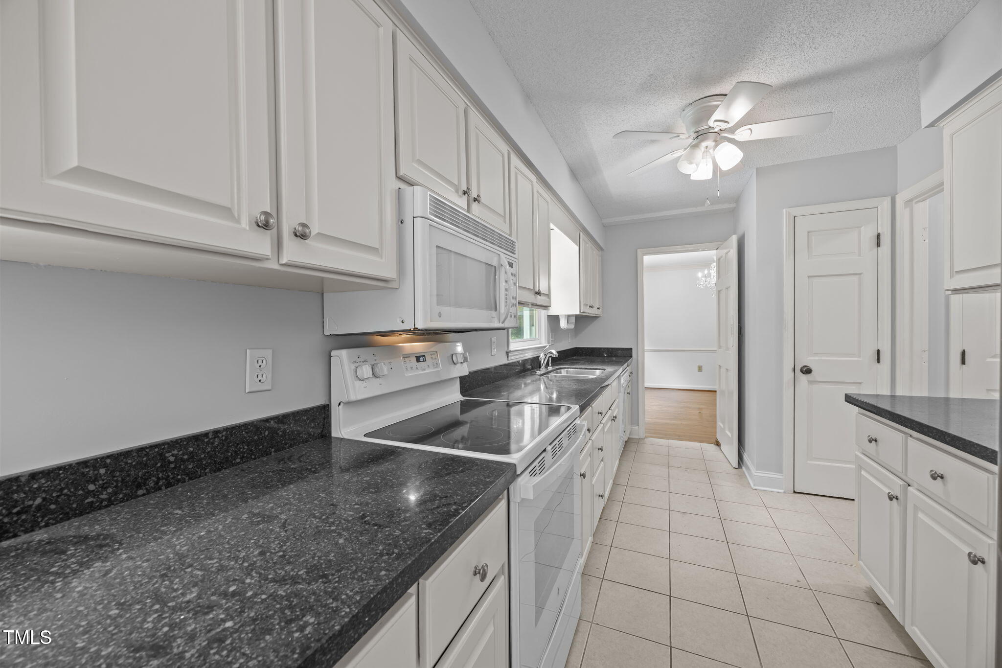 8909 Creekstone Court, Unit 11 Raleigh, NC 27615 - Photo 9 of 39 a kitchen with stainless steel appliances granite countertop a sink and dishwasher with white cabinets