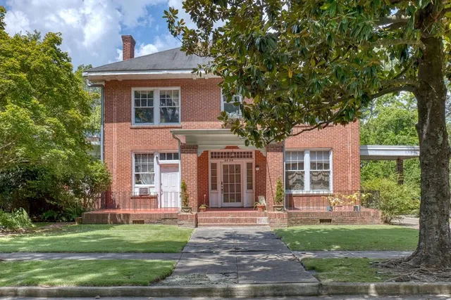 a front view of a house with a garden