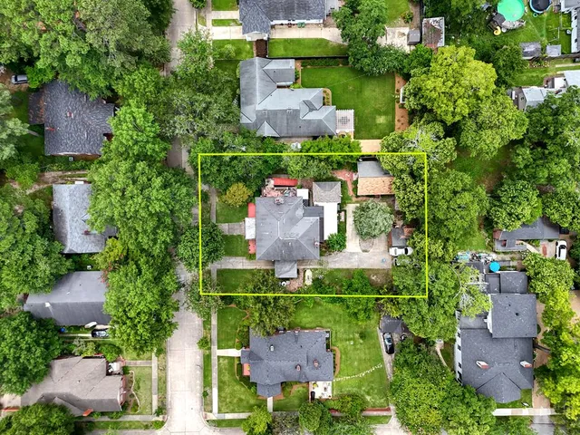 an aerial view of a house with a garden and outdoor seating