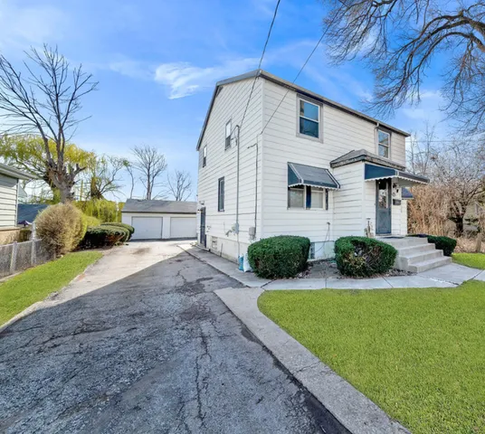 a view of a house with backyard and tree s